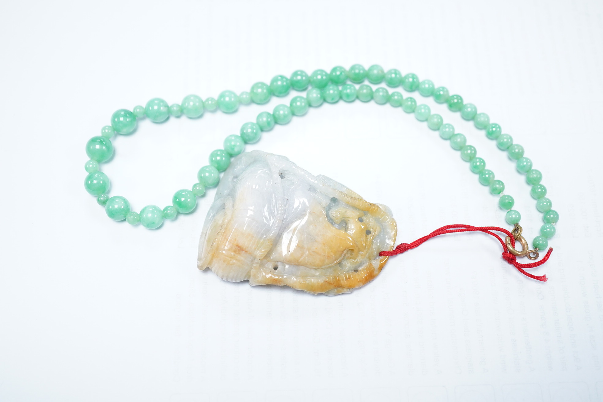 A Chinese jadeite carving and jadeite bead necklace, carving 6.5cm long. Condition - good